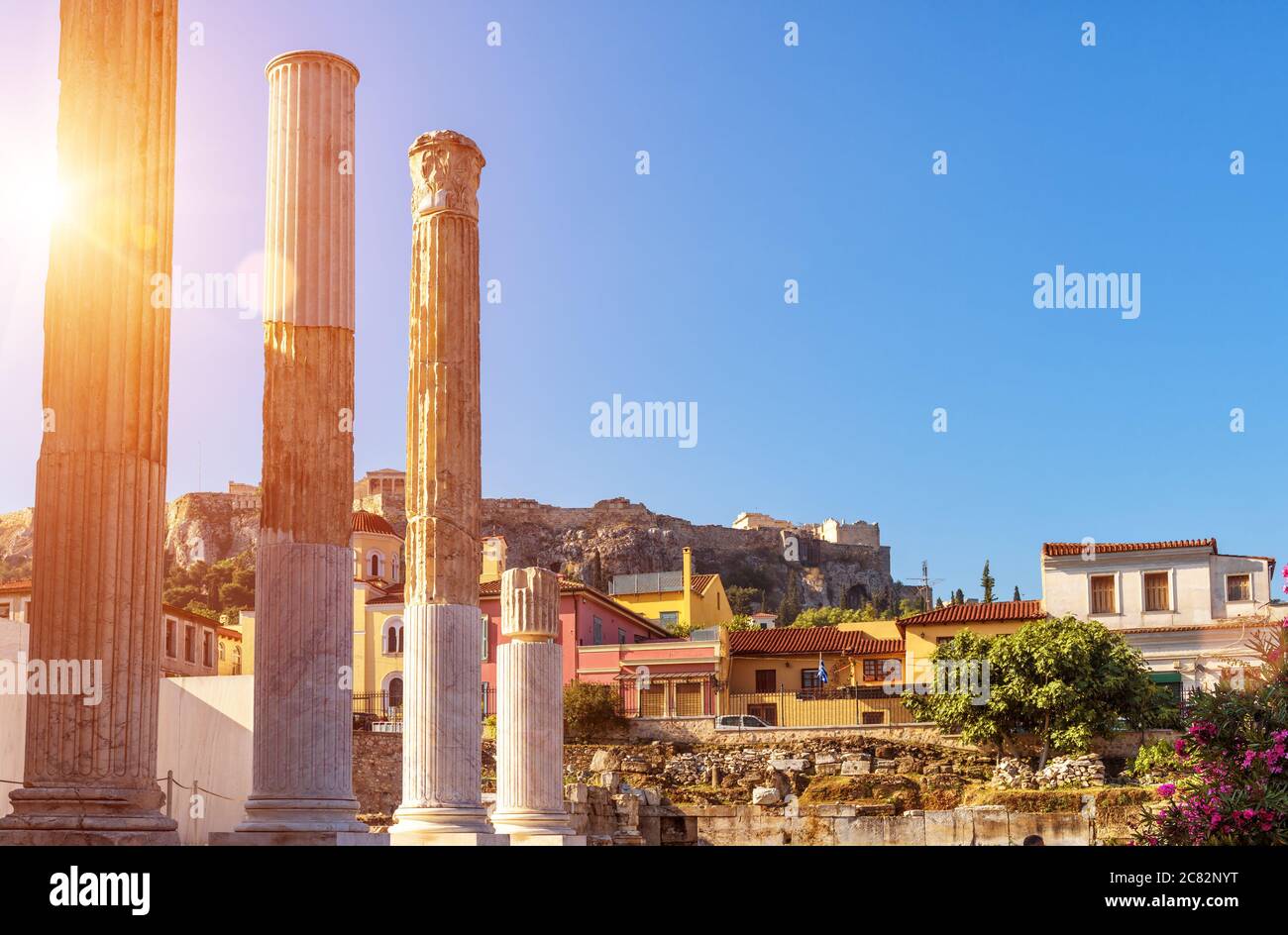 Hadrian`s Bibliothek im Sonnenlicht, Akropolis in der Ferne, Athen, Griechenland. Es sind berühmte Wahrzeichen von Athen. Städtische sonnige Landschaft von Athen mit alten Stockfoto
